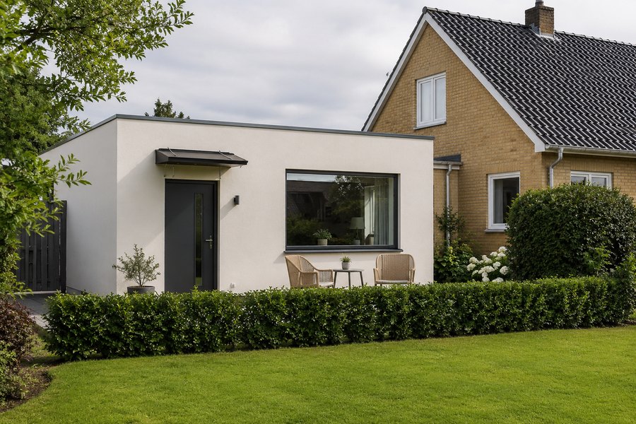 Een aanbouw met eigen voordeur en terras aan de zijkant van een gewoon woonhuis